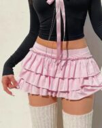 Bowed pink ruffled coquette aesthetic skirt with lace trim and thigh-high socks.