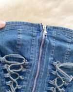 Close-up of a blue coquette denim set featuring a zipper and lacing details.