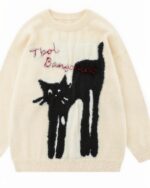 Cream-colored cat embroidered sweater with a stretched cat design and text.