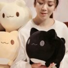 Black round neko plushie displayed in a person's hand.