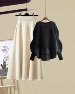 Black knit sweater and cream pleated korean aesthetic set, displayed on a hanger.
