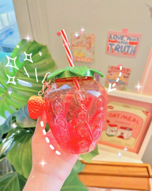 Pink strawberry water bottle with straw and fruit charm.