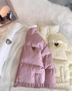 Two bear heart jackets, a pink and a beige, displayed on a white surface.