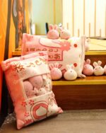 A large snack bag plushies set with pink bunny figures, displayed on a decorative pillow.