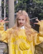 Person wearing a yellow vintage banana sweater with smiling banana illustrations.