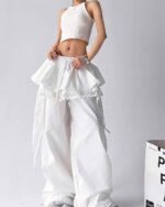 White y2k cargo pants with a ruffled skirt and lace details, worn by a model.