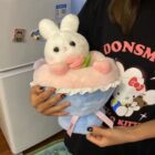 A pink bouquet rabbit plushie held by a person's hands.