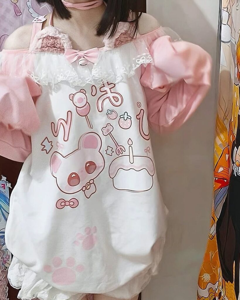 Pink pastel yume kawaii shirt featuring cute cartoon characters and floral accents.