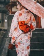 A woman wearing a patterned summer anime yukata in a Japanese setting.
