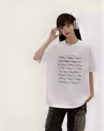 The Hidden Valley Tee featuring an artsy aesthetic design with musical notation.