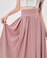 Detailed view of a long, loose korean aesthetic skirt in a blush pink color, showcasing its gathered pleats and high waist.
