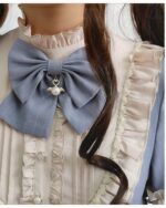 Close-up of a classic lolita dress featuring a large blue bow and ruffles.