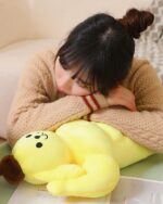Yellow sanrio muscular plushie from Strong Squishy Crew, resting on a person's lap.