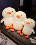 Three kawaii duck plushies, Winston the Duck, arranged together. They are white with orange beaks and feet.