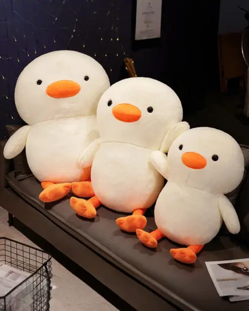 Three kawaii duck plushies, Winston the Duck, arranged together. They are white with orange beaks and feet.