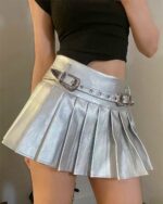 Silver pleated skirt with metallic finish and decorative buckles.