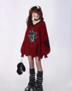 Woman wearing a red loose gothic sweater with a spider web design, accessorized with black socks and boots.