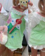 Close-up of a kawaii lime shirt featuring star and bunny motifs, pink trim, and a Harajuku aesthetic.