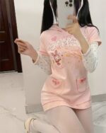 Pink pastel hooded dress featuring a cute graphic design and layered sleeves.