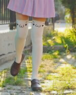 Close-up of white kaomoji stockings featuring kawaii cat face designs.