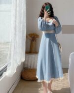 Woman wearing a blue Retro Square Collar Dress - French Aesthetic, with lace details and puffed sleeves.