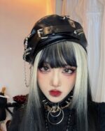 Black vegan leather studded punk beret worn by a person.