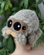 Close-up of a gray lucas the spider plush toy with large eyes and fluffy legs.