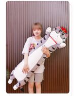 Long cat plushie, Whiskers the Stripped Emperor Cat, held by a woman.