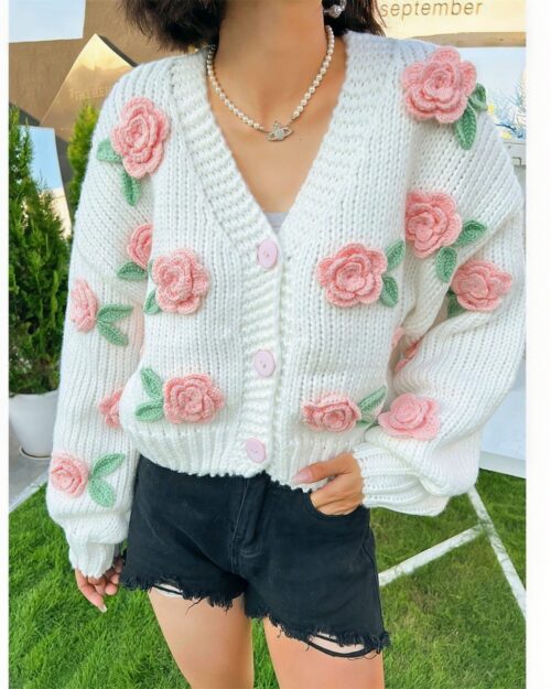 White vintage aesthetic cardigan with floral crochet embellishments and button closure.