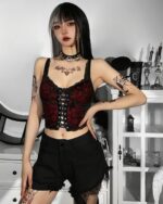 Red gothic lace vest with straps, worn by a model, featuring a lace trim and corset style.