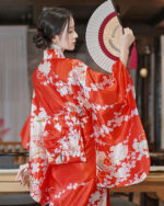 Satin-fabric japanese floral kimono featuring a vibrant red design with floral motifs and a fan.