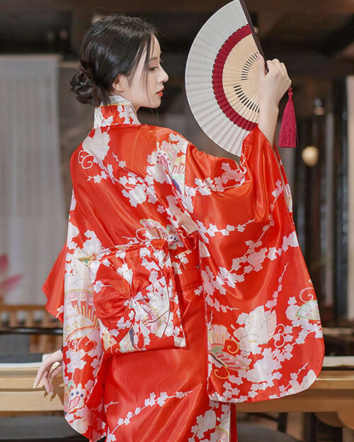 Satin-fabric japanese floral kimono featuring a vibrant red design with floral motifs and a fan.