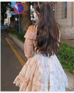 Soft girl dress in a floral print, light pink and white, with a layered skirt.