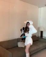 Woman wearing white bear pajamas, fluffy loungewear with hood, kawaii style.