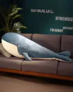 Kawaii whale plushie, Bubbles, resting on a sofa with a plush pillow.