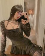 Woman wearing a lace gothic aesthetic dress, long sleeves, and crown.