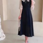 Black puff sleeve dress with a high collar, embodying a french aesthetic dress.