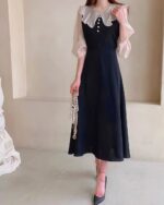 Black puff sleeve dress with a high collar, embodying a french aesthetic dress.