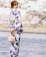 Woman wearing a blue japanese yukata with floral pattern, summer aesthetic.