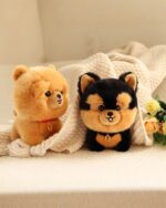 Two adorable puppy collectible plush toys, a brown and a black, displayed on a soft blanket.