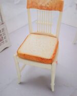 White chair with a toast cat bed cushion, featuring a realistic bread design.