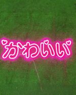 Pink "kawaii neon light" Japanese Kana decoration on green grass.