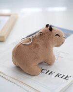 Cute brown capybara plush keychain attached to a keyring.
