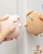 Kawaii piggy keychain plushie in beige and pink, shown being held.
