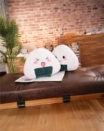 Two Kawaii onigiri plushies displayed on a brown leather sofa.
