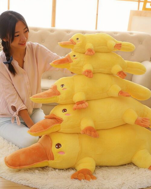 Stack of kawaii platypus plushies in various sizes, soft and cuddly toys.