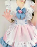 Close-up of a yume kawaii maid dress, featuring pink and white layers, a blue bow, and a paw print detail.