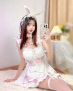 Bunny girl maid costume featuring a white and pink frilly dress with bunny ears and legwarmers.