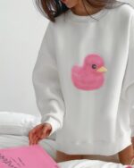 White pink duck sweater featuring a cute graphic on the front.