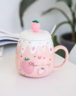 Pink strawberry ceramic mug with a strawberry lid and spoon. Product keyword: strawberry ceramic mug.